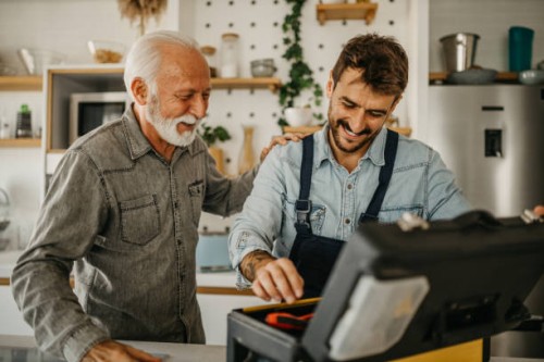 a dedicated male carpenter adeptly works on the installation and repair of kitchen components in a senior gentleman's residence, showcasing professionalism and expertise - home decoration stock pictures, royalty-free photos &