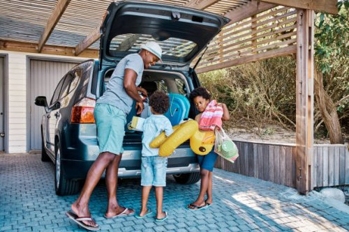 a family packing the car to leave for summer vacation. a happy african american father and his two cute little sons preparing the luggage in his vehicle to go on a road trip, ready for travel time - travel stock pictures, roy