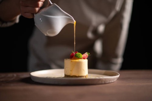 a female chef pouring sauce on a fruitcake - food stock pictures, royalty-free photos & images