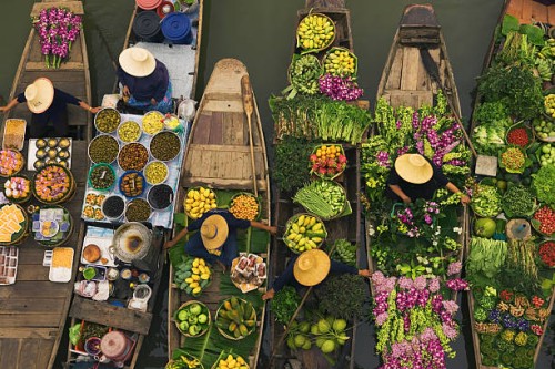 a floating market on a canal in thailand. boats laden with fresh produce, vegetables and fruit. market traders. - food stock pictures, royalty-free photos & images