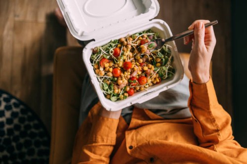a from above shot of an unrecognizable female sitting and eating some healthy colourful food from her lunchbox - junk food stock pictures, royalty-free photos & images