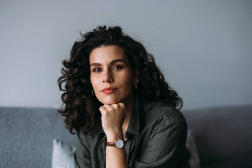 a happy beautiful businesswoman looking at camera while relaxing at home - hairstyle stock pictures, royalty-free photos & images