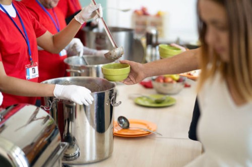 a line of hands serving food in a soup kitchen - food stock pictures, royalty-free photos & images
