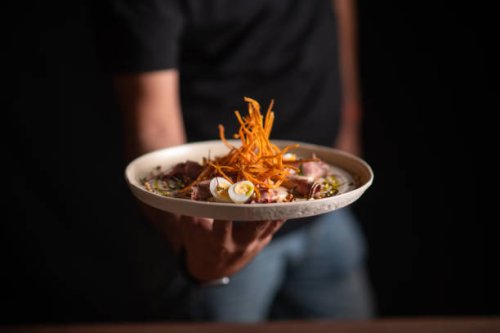 a male chef serving a fine dining dish in a restaurant - food stock pictures, royalty-free photos & images