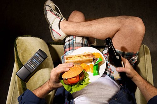 a man eats junk food - junk food stock pictures, royalty-free photos & images