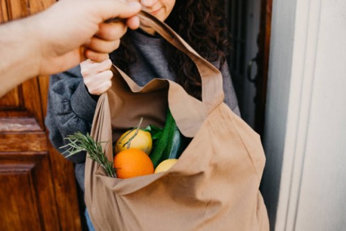 a man is delivering a bag of vegetables and fruit - food stock pictures, royalty-free photos & images