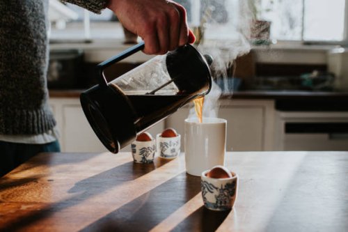 a man pours a cup of coffee from a french press coffee maker - coffee stock pictures, royalty-free photos & images