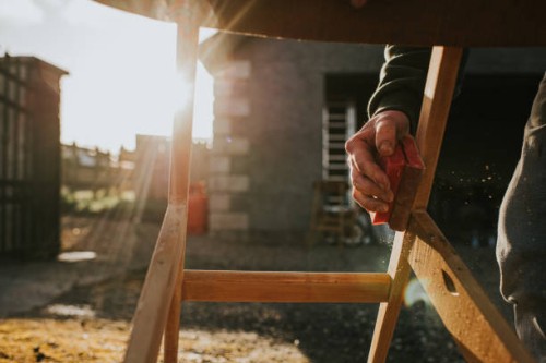 a man sanding a wooden chair frame with a sanding block - home decoration stock pictures, royalty-free photos & images