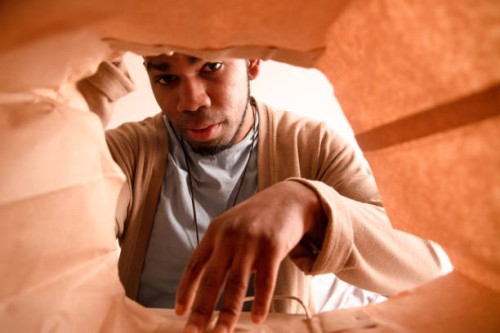 a man taking out a paper bag with items ordered through home delivery. - junk food stock pictures, royalty-free photos & images