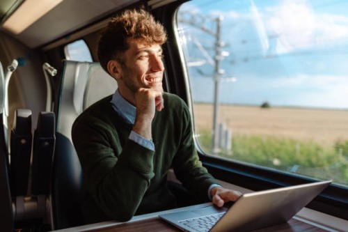 a man using a laptop during a train ride - travel stock pictures, royalty-free photos & images