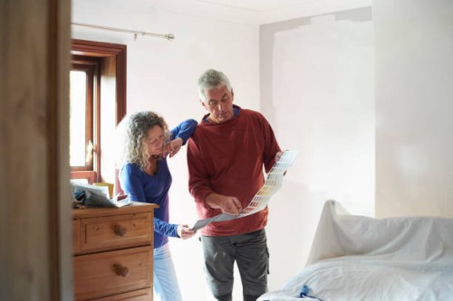 a mature couple looking at a paint colour chart - home decoration stock pictures, royalty-free photos & images