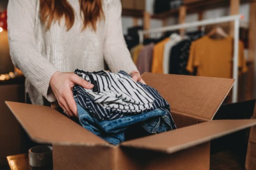 a millennial woman is preparing the shipment of some clothes in her new online shop - fashion stock pictures, royalty-free photos & images