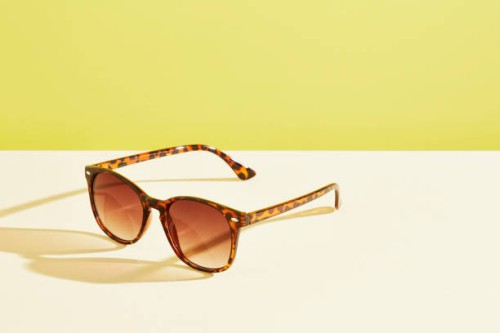 a pair of sunglasses against a yellow background - fashion stock pictures, royalty-free photos & images