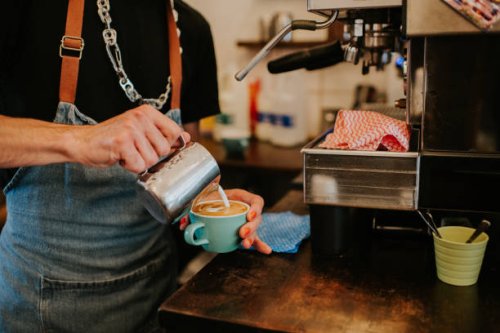a professional barista makes a coffee in a cafe - coffee stock pictures, royalty-free photos & images