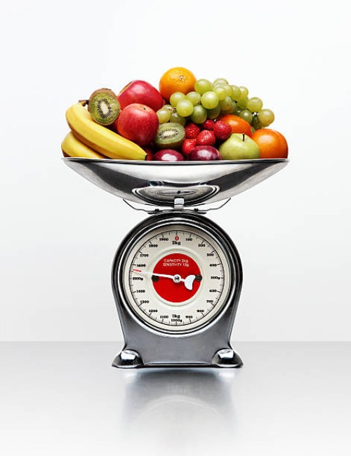 a selection of fruit on a weighing scale - food stockfoto's en -beelden