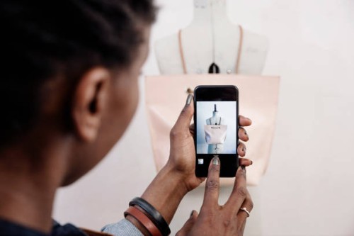 a small business owner takes a photo of her handmade leather bag, ready to upload to her website - fashion stock-fotos und bilder