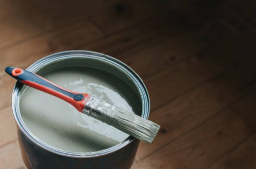 a small paintbrush sits on top of a large tin of light green / grey paint - home decoration stock pictures, royalty-free photos & images