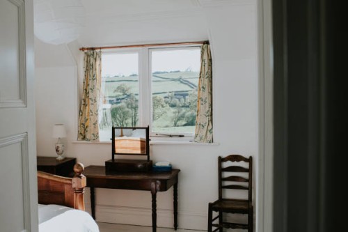 a stylish, tidy bedroom painted white, with a beautiful countryside view - home decoration stock-fotos und bilder