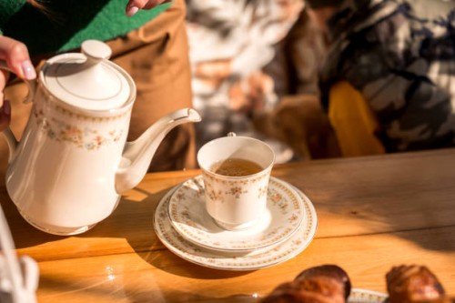 a teapot and a cup of tea on the table in the sunlight. - garden decoration photos et images de collection