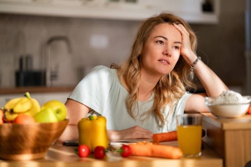 a tired woman is trying to prepare lunch while sitting in the kitchen - food stock pictures, royalty-free photos & images