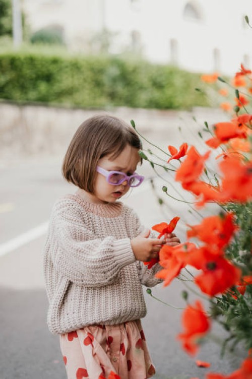 a toddler girl in a stylish outfit with purple glasses on a floral background - fashion stock pictures, royalty-free photos & images