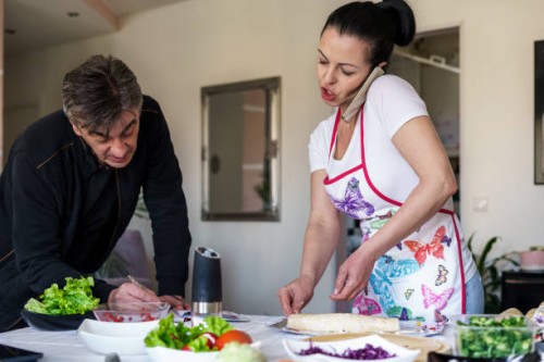 a woman and her coworker are making burritos and receiving orders via phone. - junk food stock pictures, royalty-free photos & images
