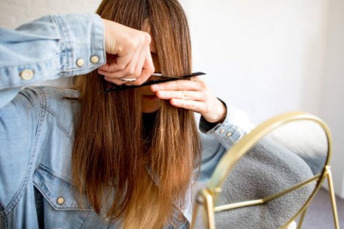 a woman cutting her own hair - hairstyle stock-fotos und bilder