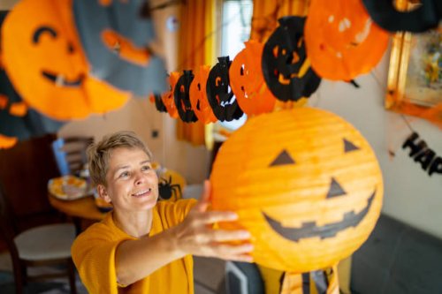 a woman hanging a jack o' lantern halloween decoration - home decoration stock pictures, royalty-free photos & images