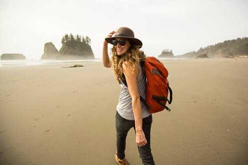a woman hiking along a remote beach. - travel stock pictures, royalty-free photos & images