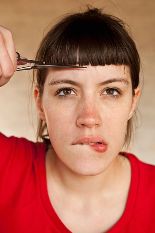 a woman trimming her own bangs - hairstyle stock pictures, royalty-free photos & images