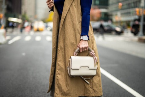 a woman with a smart watch holding a bag on the street of manhattan during busy working week - fashion stock pictures, royalty-free photos & images