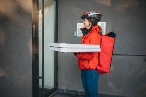 a young caucasian female delivery girl carries pizza boxes - junk food stock pictures, royalty-free photos & images