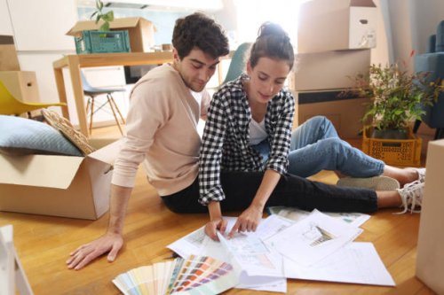 a young couple looking at plans of their new home - home decoration stock pictures, royalty-free photos & images