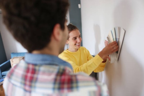 a young couple picking paint colors for new home - home decoration stockfoto's en -beelden