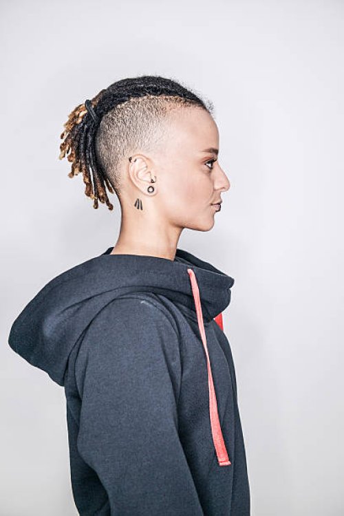 a young mixed race woman posing in a studio in profile - hairstyle stockfoto's en -beelden