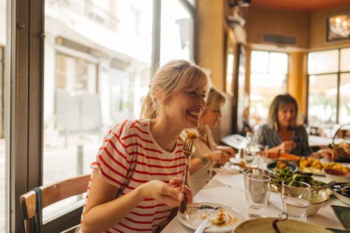 a young woman eating in a restaurant - food stock pictures, royalty-free photos & images