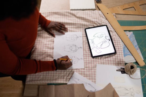 above view of black fashion designer sketching and using touchpad in a design studio. - fashion stock pictures, royalty-free photos & images