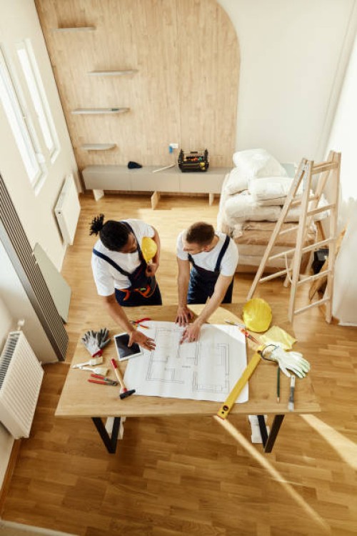 above view of manual workers analyzing blueprints in moving apartment. - home decoration stock pictures, royalty-free photos & images