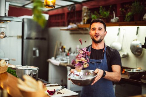 action portrait of male chef tossing ingredients in bowl - food stock pictures, royalty-free photos & images