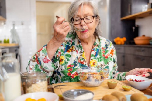 active senior woman is enjoying her healthy breakfast - food stock pictures, royalty-free photos & images