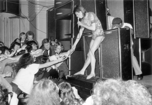 Adoring fans reaching out to touch the hand of the English pop star, David Bowie, during the concert at the Hammersmith Odeon where Bowie announced...