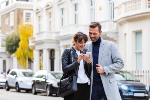 adult couple using smart phone together in the city street - fashion stock pictures, royalty-free photos & images
