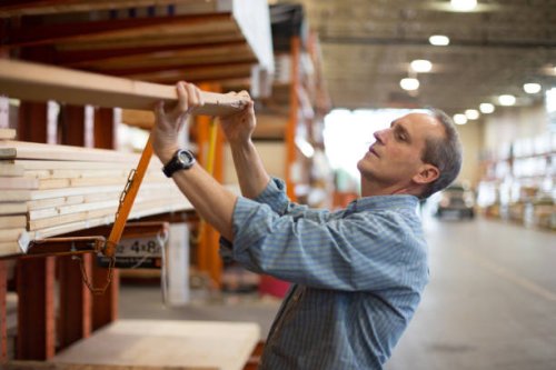 adult male customer in hardware store choosing lumber - home decoration stock pictures, royalty-free photos & images