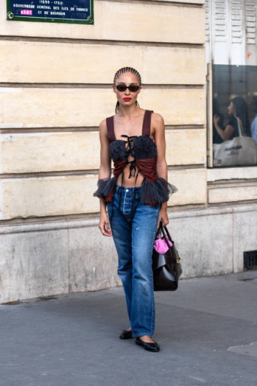 Adwoa Aboah wears a lace up top, blue jeans, black bag and sunglasses and black Chanel ballet shoes outside the Chloe show during the Womenswear...