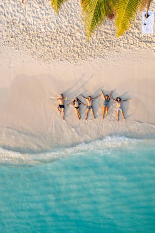 aerial view of friends lying down on the beach - travel stock pictures, royalty-free photos & images