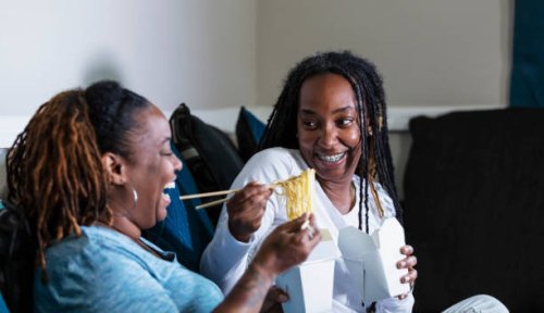 african-american lesbian couple watch tv, eat take out - junk food stock pictures, royalty-free photos & images