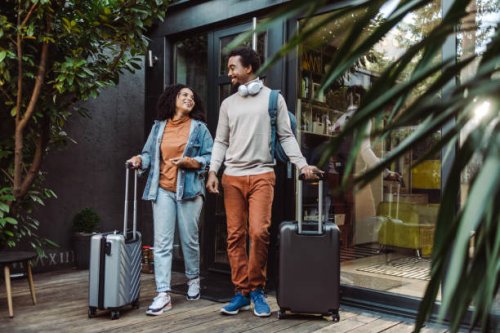 african-american tourists with suitcases in front of the rented apartment - travel stock pictures, royalty-free photos & images