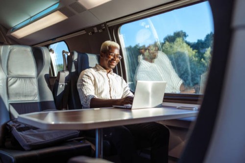 african american businessman working on laptop at the train - travel stock pictures, royalty-free photos & images