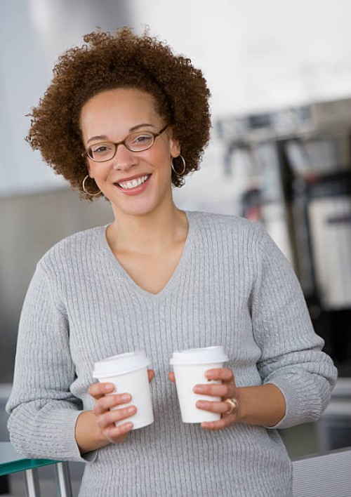 african businesswoman holding take out coffees - junk food stock pictures, royalty-free photos & images