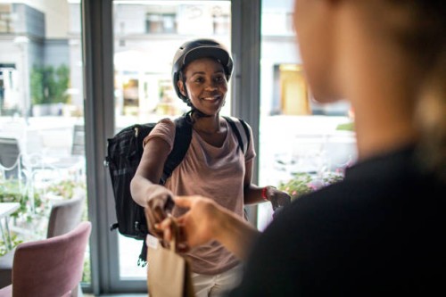 african delivery woman delivering package to customer - junk food stock pictures, royalty-free photos & images